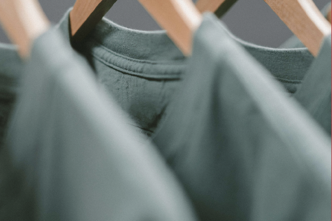 gray green shirts hanging from hangers