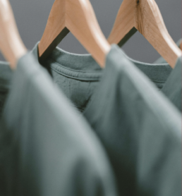 gray green shirts hanging from hangers